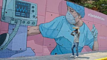 A man walks past a coronavirus-related mural reading Stay at home, in Acapulco, Guerrero state, Mexico, on May 1, 2020. (Photo by FRANCISCO ROBLES / AFP)