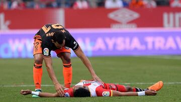 Valencia's Spanish defender Martin Montoya (L) approaches Girona's Colombian defender Johan Mojica lying on the field during the Spanish league football match Girona FC vs Valencia CF at the Municipal de Montilivi stadium in Girona on May 12, 20