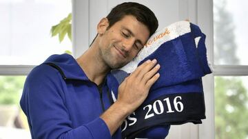 El tenista serbio Novak Djokovic sonríe tras recibir una toalla con su nombre bordado como regalo de parte de la organización de Roland Garros para celebrar su vigésimo noveno cumpleaños.