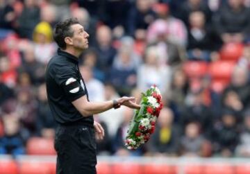 ?rbitro Lee Probert lleva una corona de flores en memoria del desastre de Hillsborough por delante del partido de f¨²tbol Ingl¨¦s Premier League entre Sunderland y Everton en el Estadio de la Luz en Sunderland.