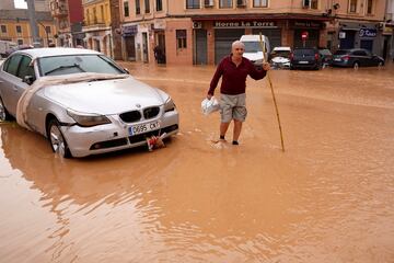 Un hombre recorre las calles inundadas de Valencia tras la inundaciones producidas por la ADANA.