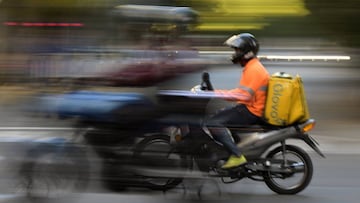 (FILES) In this file photo taken on April 17, 2020 a delivery boy rides a motorcycle in Buenos Aires, amid the COVID-19 coronavirus pandemic. - With the arrival of the Covid-19 pandemic in Argentina, employees in restaurants, dog walkers, recyclers, bricklayers, and cleaning personnel found themselves out of work from one day to the next, with no other safeguard than home delivery or state subsidies. (Photo by JUAN MABROMATA / AFP)