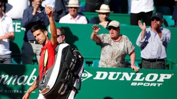 Novak Djokovic waves to spectators as he leaves the court. 