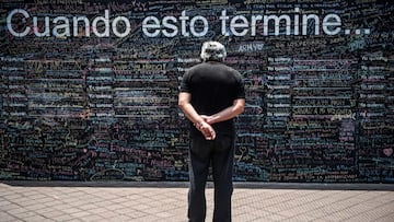 A man looks at a giant blackboard where people write what they want to do when the new coronavirus pandemic is over, in Lima on October 26, 2020. - On giant blackboards placed in two squares in Lima, people can write with colored chalk what they want to do &quot;when this is over.&quot; (Photo by ERNESTO BENAVIDES / AFP)