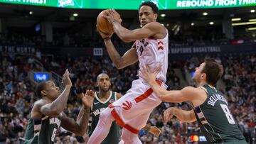 Jan 1, 2018; Toronto, Ontario, CAN; Toronto Raptors guard DeMar DeRozan (10) shoots the ball as Milwaukee Bucks guard Matthew Dellavedova (8) and guard Eric Bledsoe (6) defend during the second half at Air Canada Centre. Mandatory Credit: Kevin Sousa-USA