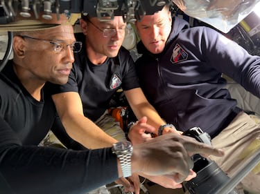 Los astronautas de la NASA Victor Glover y el comandante Reid Wiseman se preparan para su viaje alrededor de la cara oculta de la Luna junto al astronauta de la Agencia Espacial Canadiense (CSA), Jeremy Hansen, configurando su equipo de cámara para su uso a través de la ventana de la nave espacial Orión, poco antes de su sobrevuelo lunar. 