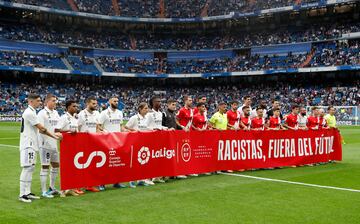 Jugadores del Real Madrid y del Rayo, junto al equipo arbitral, portan la pancarta contra el racismo.