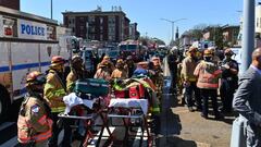 A man in a construction vest, grey hoodie and gas mask has attacked and shot at least 10 people at a subway station in NYC.