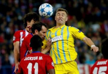 El defensa uruguayo del Atlético de Madrid Diego Godín salta por el balón con Aleksey Shchetkin, centrocampista del Astana