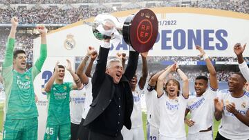 Carlo Ancelotti, entrenador del Real Madrid, levanta el trofeo de campe&oacute;n de Liga sobre el c&eacute;sped del Bernab&eacute;u.