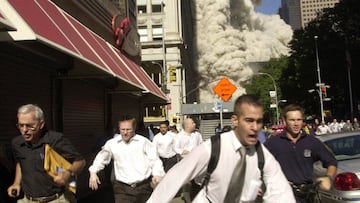 ARCHIVO - En esta foto de archivo del 11 de septiembre de 2001, las personas huyen del colapso de una de las torres gemelas en el World Trade Center de Nueva York.