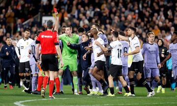 Los jugadores del Real Madrid protestan al árbitro del encuentro, Gil Manzano, tras la decisión de anular el gol a Jude Bellingham. En la imagen, el colegiado muestra la tarjeta roja al jugador inglés.