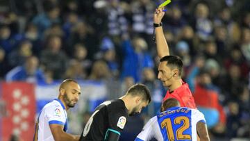 El &aacute;rbitro S&aacute;nchez Mart&iacute;nez muestra una amarilla a El Zhar durante el partido de Copa del Rey entre Legan&eacute;s y Real Madrid.