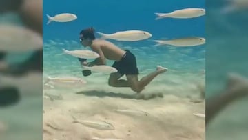 El surfista Kai Lenny entrenando bajo el agua con pesas entre peces. 