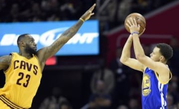 El jugador Stephen Curry de los Golden State Warriors lanza frente a LeBron James de los Cavaliers durante el tercer partido de la serie final de la NBA