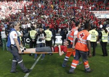 GRA262. PAMPLONA, 18/05/2014.- Efectivos de Cruz Roja trasladan a uno de los heridos en la avalancha registrada en el estadio El Sadar tras el gol de Osasuna, en el minuto 12 del partido contra el Betis, que ha provocado el parón de momento del partido. Ninguna de las personas que han resultado heridas en la avalancha se encuentra en estado grave. EFE/Jesús Diges