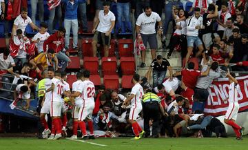 Aficionados del Sevilla caen tras ceder una de las vallas en la celebración del segundo gol del equipo andaluz, durante el encuentro correspondiente a la séptima jornada de primera división que disputan esta tarde frente al Eibar en el estadio de Ipurua,