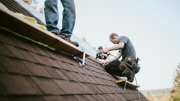 A roofer and crew work on putting in new roofing shingles. Small local business serving local families in Washington State.