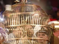 Archivo - Personas disfrazadas detrás de un bombo esperan en el Teatro Real de Madrid para disfrutar del Sorteo Extraordinario de la Lotería de Navidad.