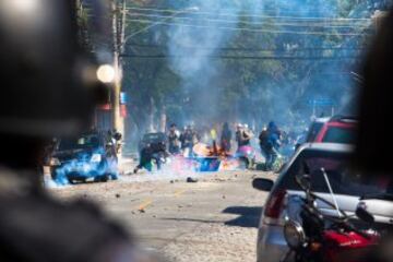 Miembros de la Policía brasileña dispersan a un grupo de manifestantes, durante la primera protesta contra el Mundial de fútbol Brasil 2014 registrada en Sao Paulo (Brasil), en el día en que comienza la competición. Cerca de 150 hombres de la Tropa de Choque de la Policía Militarizada del estado de Sao Paulo dispersaron a un grupo de 50 manifestantes que intentaba marchar por la avenida Radial Este, la principal vía de acceso al Arena Corinthians, el estadio de Sao Paulo en que se disputará el partido inaugural del Mundial.