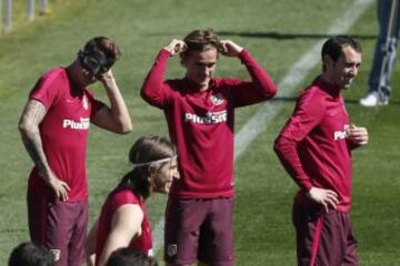 Los jugadores del Atlético de Madrid Antoine Griezman y los uruguayos Diego Godín y José María Giménez durante el entrenamiento esta mañana en el Cerro del Espino previo al partido de mañana ante el Sevilla en el Vicente Calderón.