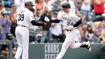 DENVER, COLORADO - SEPTEMBER 29: Ryan McMahon #24 of the Colorado Rockies is congratulate by Stu Cole #39 as he circles the bases after hitting a 3 RBI home run against the Washington Nationals in the first inning at Coors Field on September 29, 2021 in D