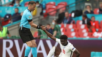 Referee Danny Makkelie helps England's Bukayo Saka during the match against Germany in the round of 16.