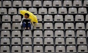 Una espectadora se protege de la lluvia bajo un paraguas después de que los partidos del torneo de Roland Garros hayan sido aplazados por la lluvia.