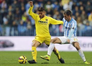 Jonathan Dos Santos lucha el balón ante el centrocampista portugués del Málaga Sergio Paulo Barbosa "Duda". 