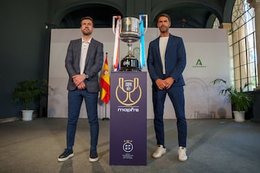 El excapitán del Atlético de Madrid, Gabi (i), y el excentrocampista de la Real Sociedad, Xabi Prieto (d), posan en una foto junto a la Copa del Rey en el Palacio de San Telmo en Sevilla.  