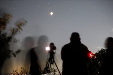 La gente toma fotografías de la Luna  durante un eclipse lunar total en Panchimalco, El Salvador.