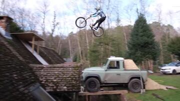 El piloto de MTB Brendan Fairclough saltando por una rampa construída gracias a su Land Rover e intentando pasar por encima el tejado de su casa.