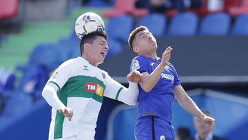 GETAFE, SPAIN - MARCH 21: Guido Carrillo (L) of Elche CF  wins the header before Francisco Portillo (R) of Getafe CF during the La Liga Santander match between Getafe CF and Elche CF at Coliseum Alfonso Perez on March 21, 2021 in Getafe, Spain. Sporting s