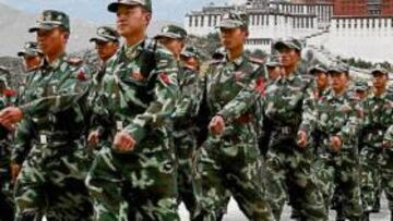 <b>VIGILANCIA ANTE EL PALACIO DEL DALAI LAMA. </b>Policías chinos desfilan en Lhasa, la capital tibetana. Al fondo, el Palacio en el que vivía el Dalai Lama antes de su exilio.