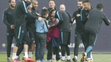 GRA187. BARCELONA, 15/03/2016.- Los jugadores del FC Barcelona con los tres niños que, burlando la seguridad del club, han accedido al entrenamiento que el club azulgrana realizaba en la ciudad deportiva Joan Gamper para preparar el partido de vuelta de octavos de final de Liga de Campeones que mañana disputarán ante el Arsenal. EFE/Andreu Dalmau