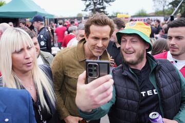 El copropietario del Wrexham, Ryan Reynolds (centro), llega al estadio Racecourse antes del partido. 