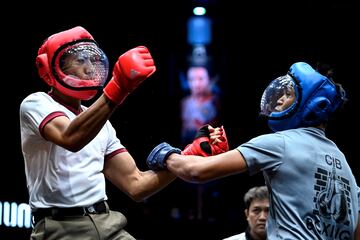 Con el fin de aumentar la confianza de los ciudadanos en la institución, la Policía Real de Tailandia ha organizado un torneo de artes marciales de un día de duración denominado Cops Combat. En la imagen, dos agentes se enfrentan en un combate en el estadio Rajadamnern de Bangkok, uno de los estadios de boxeo más antiguos de la ciudad.