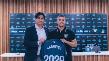 Marco Garcés, director de fútbol del Celta, y Sergio Carreira, jugador del equipo vigués, posan con una camiseta conmemorativa del acuerdo de renovación alcanzado.