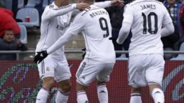 Cristiano Ronaldo es felicitado por su compañero Karim Benzema., tras conseguir el tercer gol para el Real Madrid, durante el partido de la decimonovena jornada de la Liga BBVA, que el Getafe y el Real Madrid disputaron hoy en el estadio Alfonso Pérez de Getafe.A la derecha el jugador colombiano del Real Madrid, James Rodriguez.
