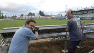 Dos operarios colocan gradas supletorias para el partido de mañana.