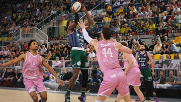 LAS PALMAS DE GRAN CANARIA, 13/02/2025.- El base estadounidense con pasaporte montenegrino del Unicaja Kendrick Perry (2i) lanza ante el pívot croata del Joventut , Ante Tomic (d) en el partido de cuartos de final de la Copa del Rey de baloncesto que se disputa este jueves en el Gran Canaria Arena. EFE/ Angel Medina G.