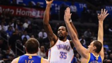 Los jugadores David Lee y Andris Biedrins de los Warriors de Golden State intentan bloquear el lanzamiento de Kevin Durant de los Thunder de Oklahoma City.