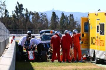 El piloto Fernando Alonso recibe atención tras un accidente durante la cuarta tanda de entrenamientos de pretemporada del Mundial de Fórmula Uno, que se realiza en el Circuito de Cataluña.