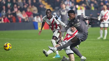 Real Madrid's Brazilian forward #07 Vinicius Junior (R) takes a shot at goal challenged by Rayo Vallecano's Albanian defender #20 Ivan Balliu Campeny during the Spanish league football match between Rayo Vallecano de Madrid and Real Madrid CF at the Vallecas stadium in Madrid on December 14, 2024. (Photo by Pierre-Philippe MARCOU / AFP)