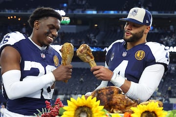 ARLINGTON, TEXAS - NOVEMBER 23: DaRon Bland #26 Dak Prescott #4 of the Dallas Cowboys take a bite out of a turkey leg after a win over the Washington Commanders at AT&T Stadium on November 23, 2023 in Arlington, Texas.   Richard Rodriguez/Getty Images/AFP (Photo by Richard Rodriguez / GETTY IMAGES NORTH AMERICA / Getty Images via AFP)