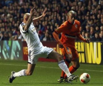 El jugador del Swansea Jonjo Shelvey (izda) pelea por el control del balón con el centrocampista argelino del Valencia, Sofiane Feghouli, durante el partido del grupo A disputado en el estadio Liberty de Swansea, Reino Unido.