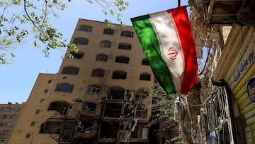An Iranian flag flutters near a residential building damaged by a strike on March 4, in Tehran, Iran, April 14, 2026. REUTERS/Thaier Al Sudani