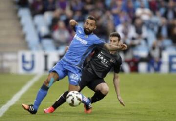 El centrocampista del Getafe Diego Castro lucha el balón con Iván López, del Levante.