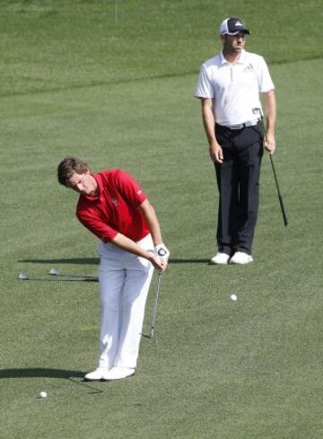 El golfista chileno Matias Domínguez (izda) golpea la bola hacia el "green" del decimoquinto hoyo junto al español Sergio García, durante la última jornada de entrenamientos para el Masters de Augusta. 