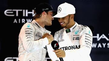 ABU DHABI, UNITED ARAB EMIRATES - NOVEMBER 27: Race winner Lewis Hamilton of Great Britain and Mercedes GP congratulates second place finisher and World Drivers Champion Nico Rosberg of Germany and Mercedes GP on the podium during the Abu Dhabi Formula One Grand Prix at Yas Marina Circuit on November 27, 2016 in Abu Dhabi, United Arab Emirates. (Photo by Clive Mason/Getty Images)